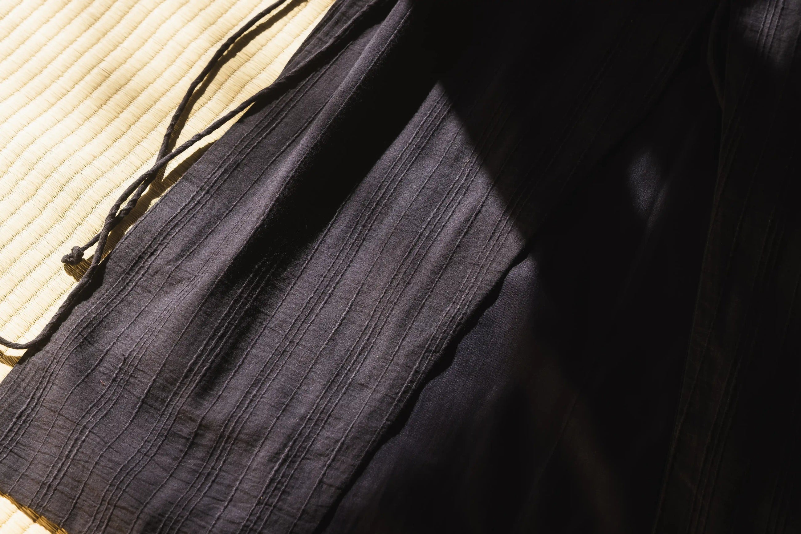 Close-up of a black fabric bag on a textured surface