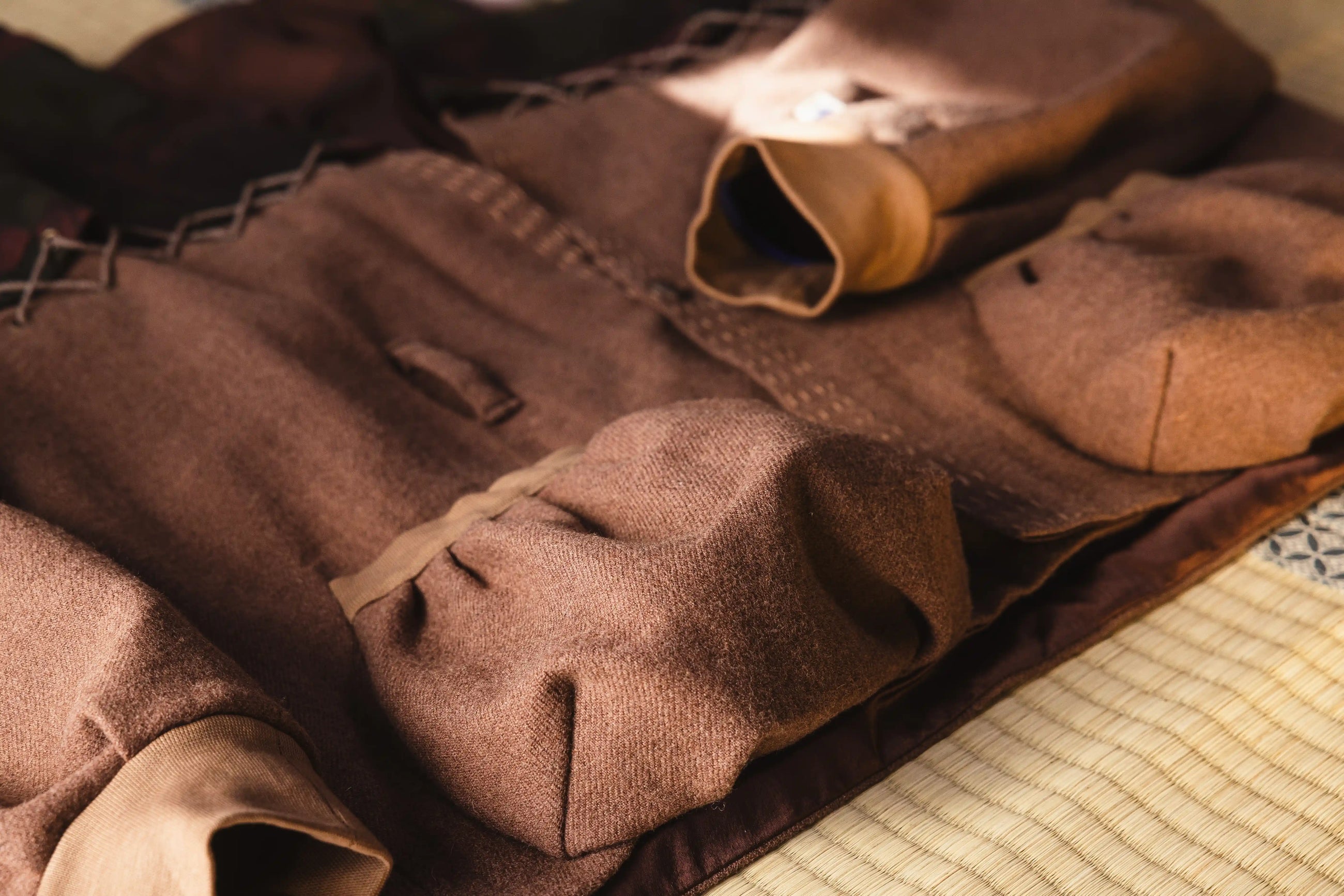 Brown fabric with stitching details on a textured surface