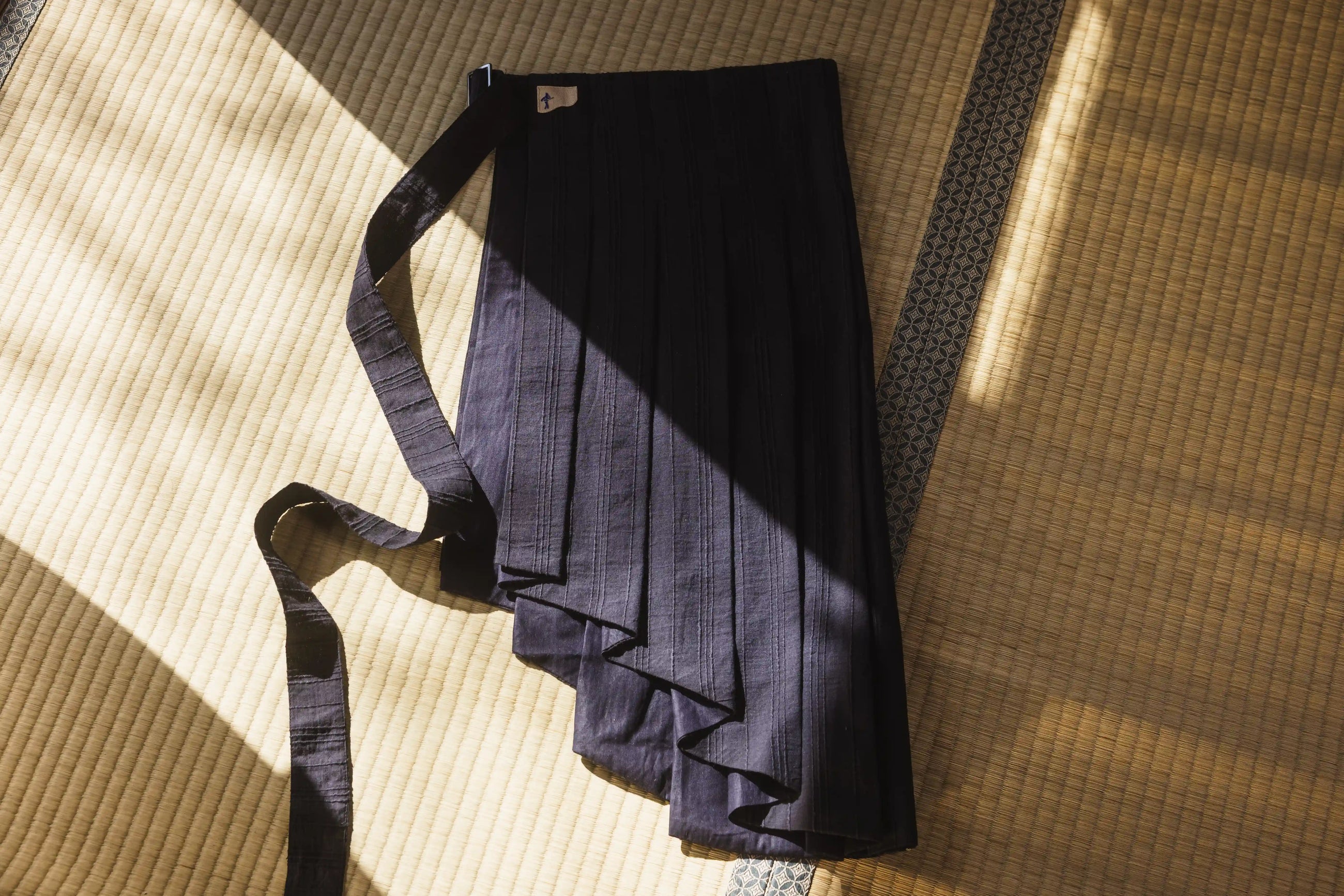 Folded dark blue fabric with a strap on a textured surface