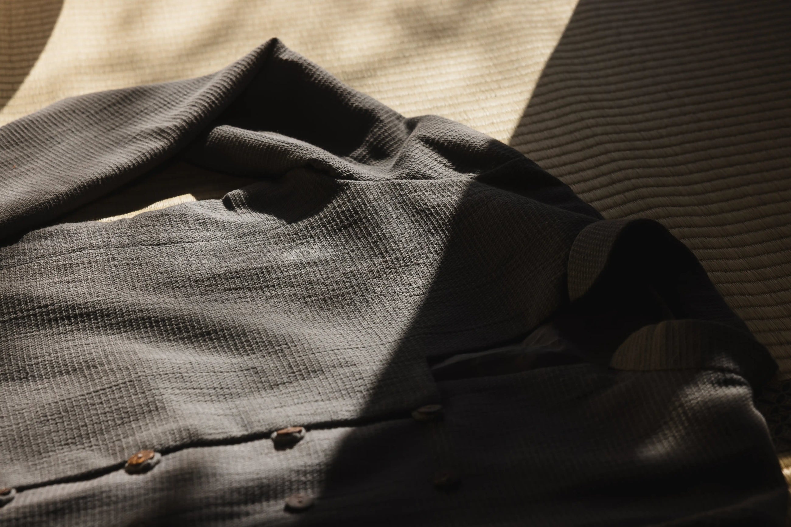 Folded dark gray shirt on a textured surface