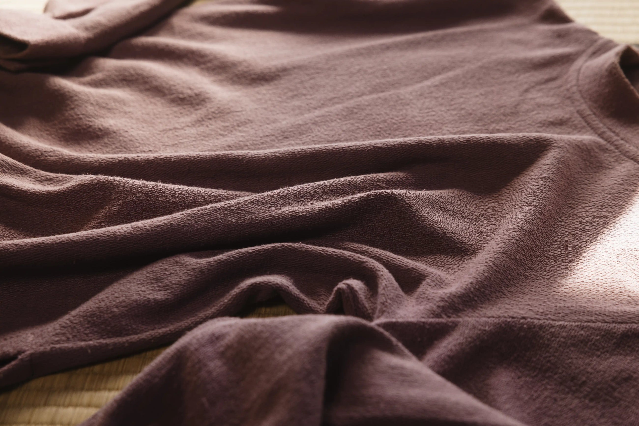 Close-up of a textured purple fabric on a wooden surface
