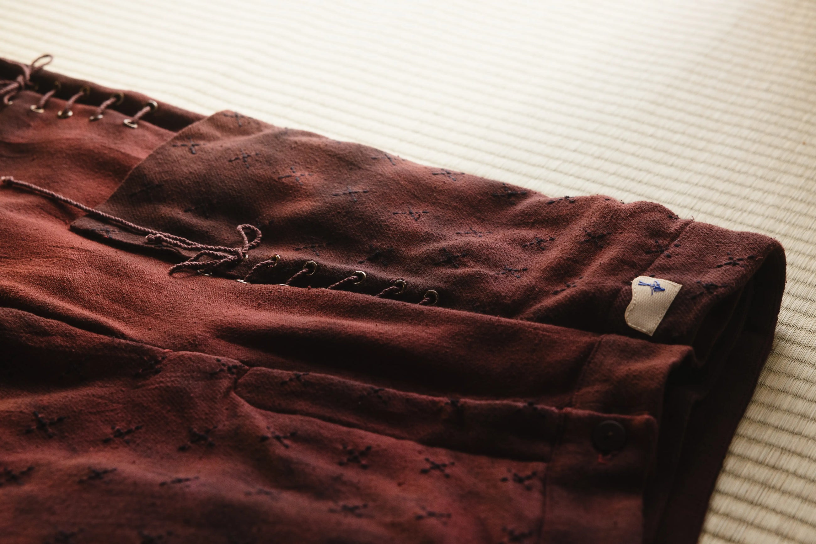Brown pants with a tag on a light-colored surface