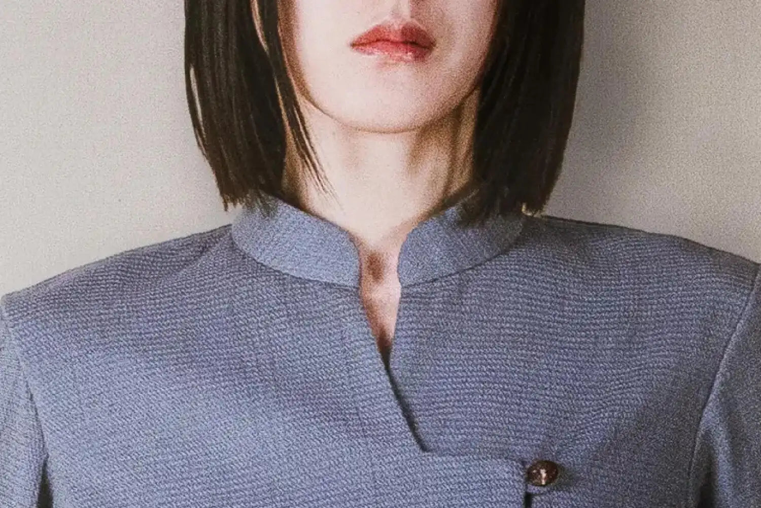 Person wearing a textured blue shirt with a plain background