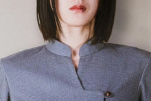 Person wearing a textured blue shirt with a plain background