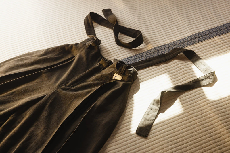 Brown dress with black straps on a textured surface