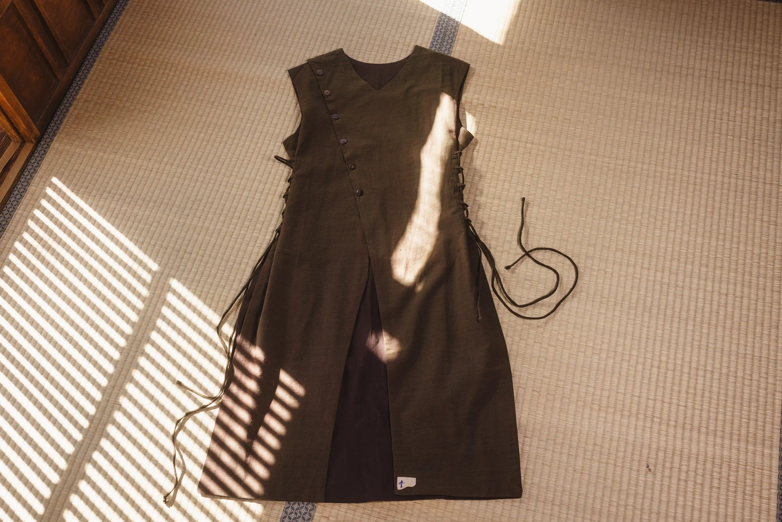 Brown dress with fringes on a textured surface