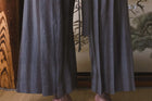 Traditional Japanese kimono worn by a person in a room with wooden elements and a painting.
