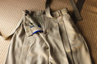 Beige corduroy pants with suspenders on a textured surface