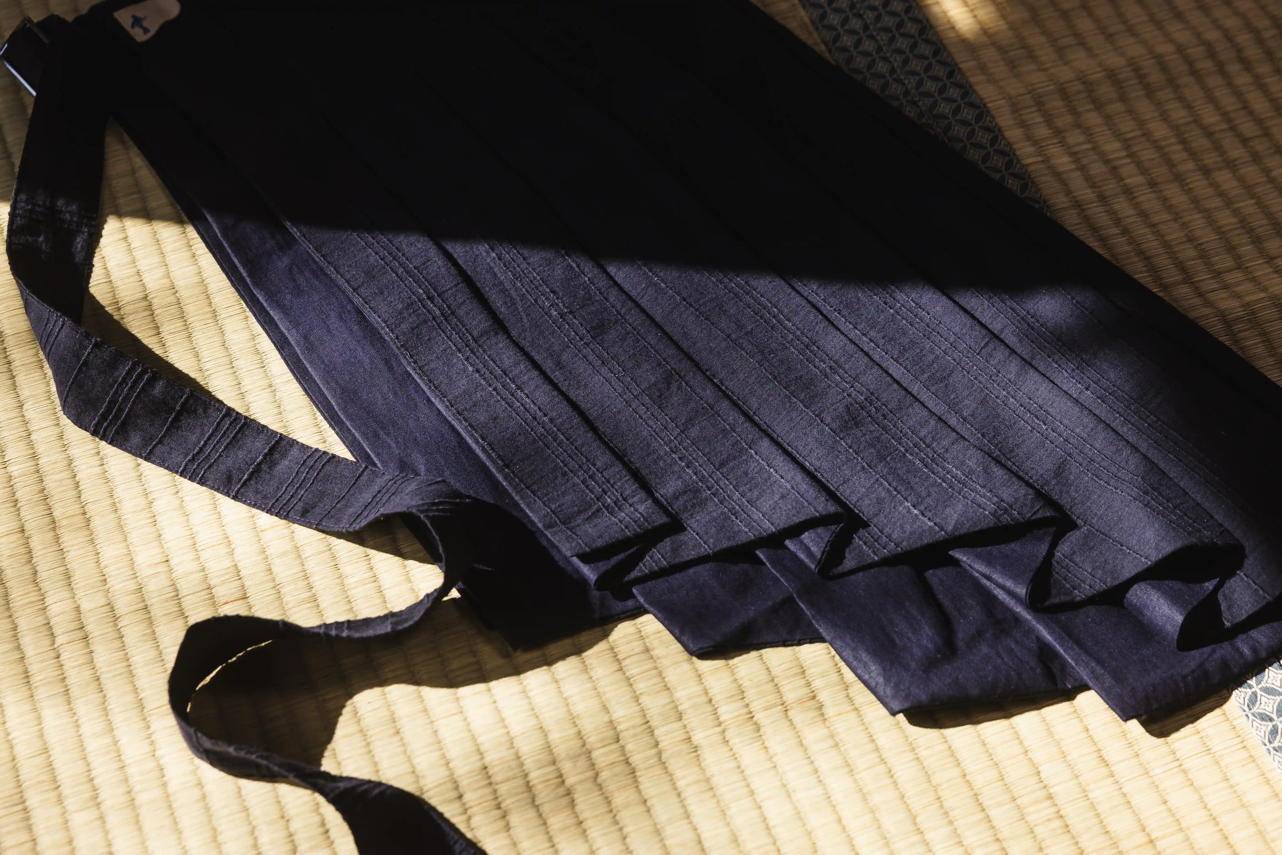 Navy blue pleated skirt on a textured surface