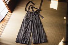 Gray jumpsuit with suspenders on a tatami mat floor