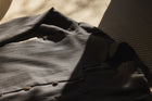 Folded dark gray shirt on a textured surface