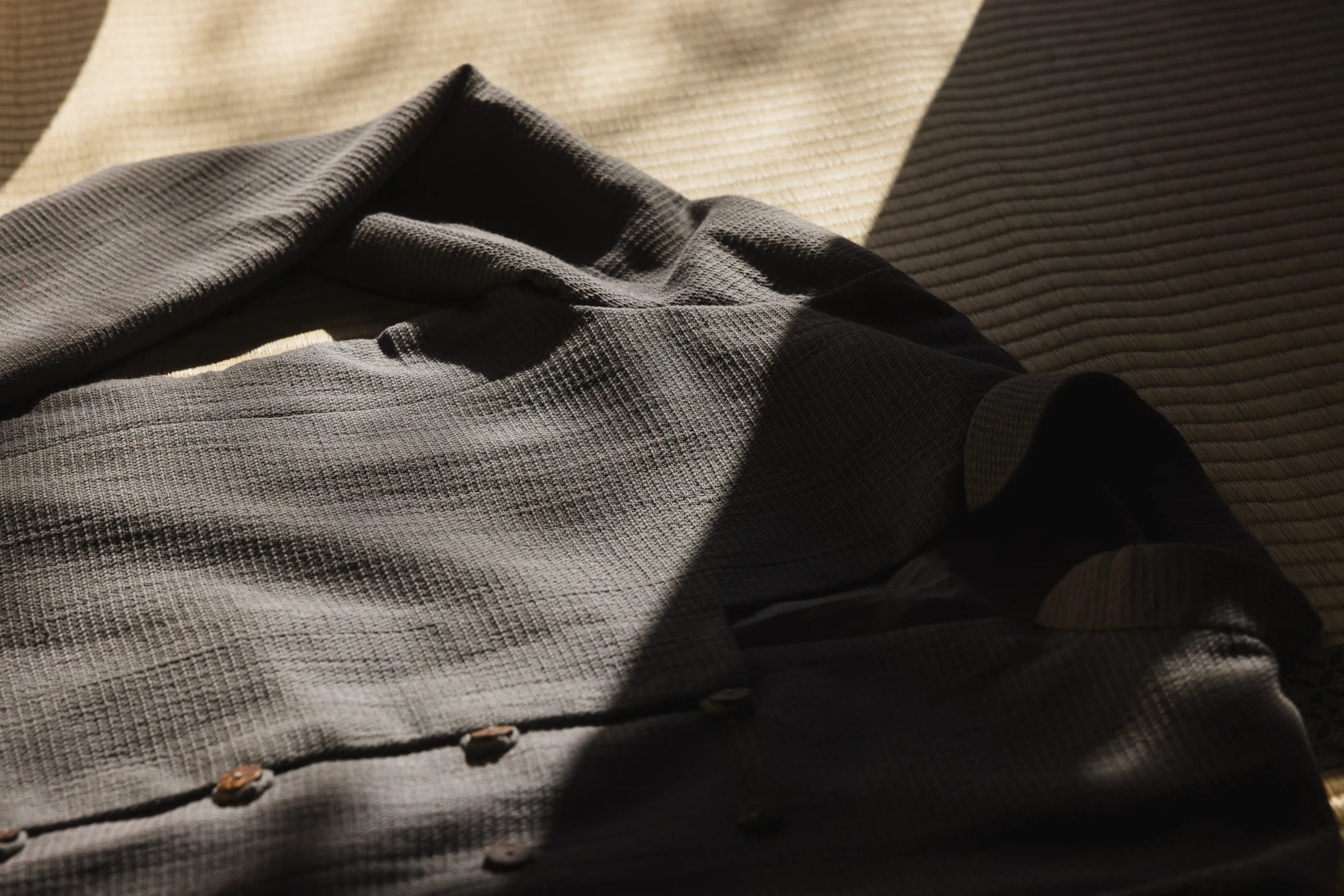 Folded dark gray shirt on a textured surface