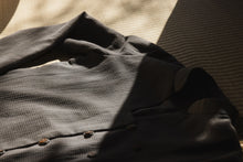 Folded dark gray shirt on a textured surface