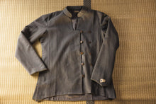 Vintage-style gray jacket with brown buttons on a textured surface