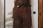 Brown leather outfit with vest and shorts on a neutral background