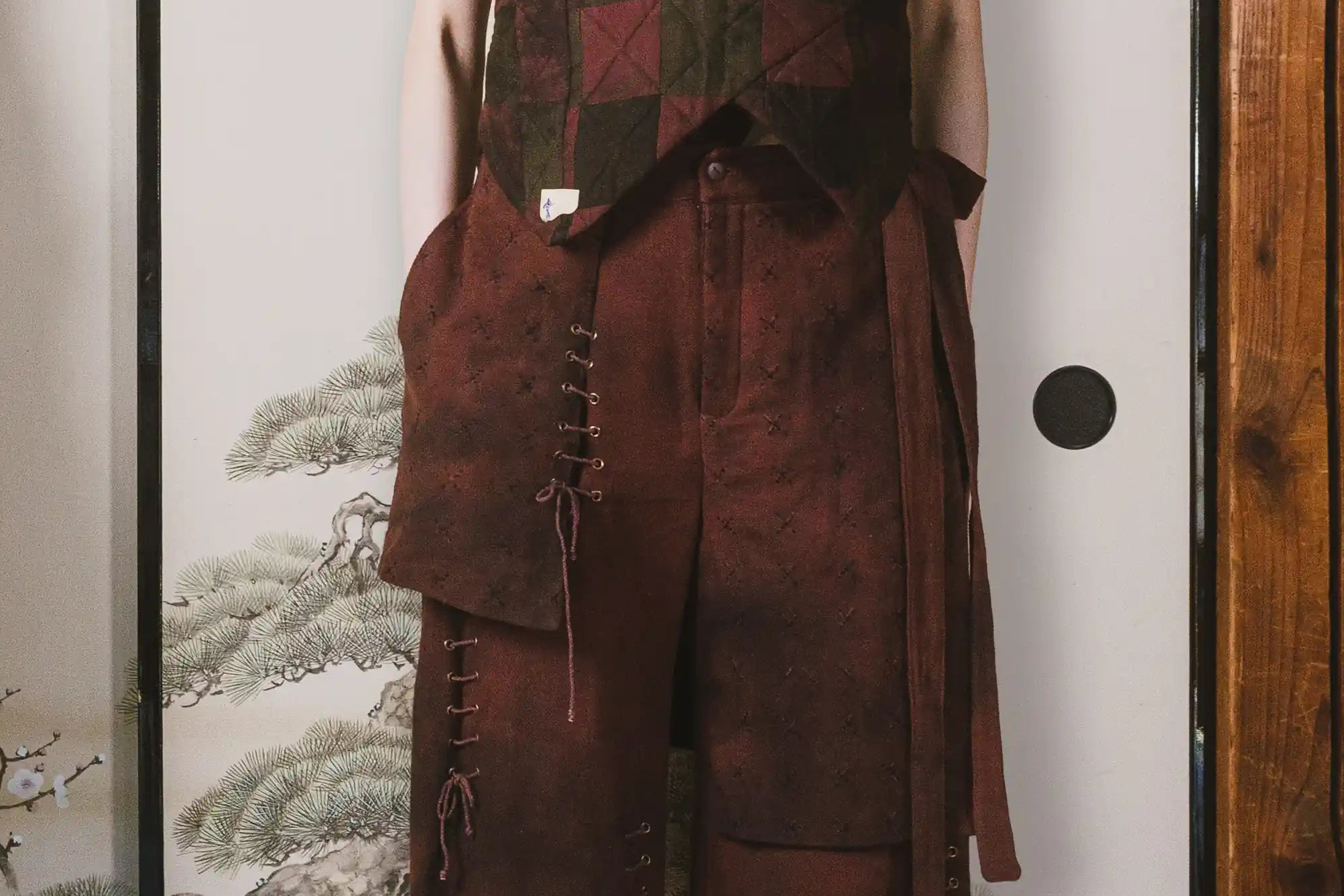 Brown leather outfit with vest and shorts on a neutral background