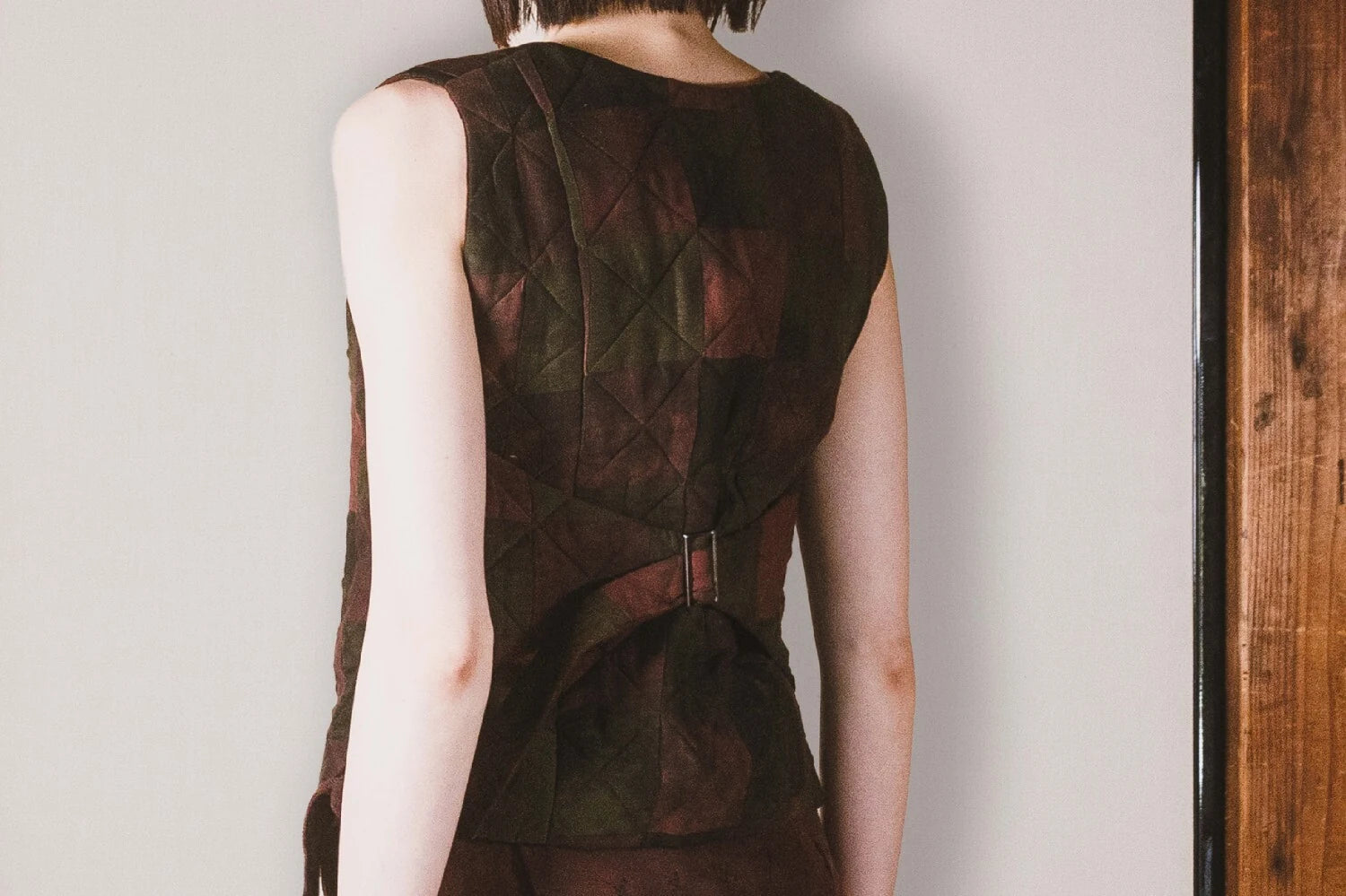Brown sleeveless top worn by a person on a plain background